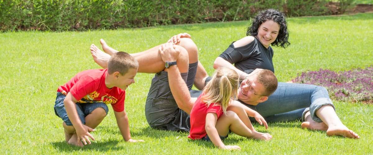 Texas family enjoying a lush green lawn after professional lawn care and fertilization service